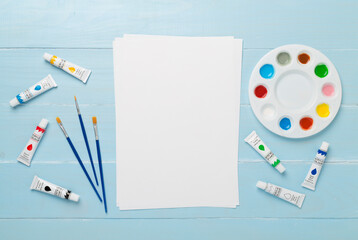 Painting tools on color wooden background, top, view