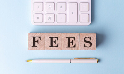 FEES on wooden cubes with pen and calculator, financial concept