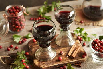 Two vintage glass cups of medicinal wine made of fresh hawthorn berries