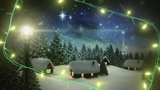 Yellow christmas string lights flashing over winter village night scene with falling snow