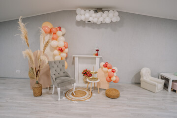 Decorations in the room include balloons and pampas, creating a boho-style atmosphere