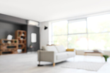 Fototapeta premium Blurred view of modern living room with sofa and soft bench