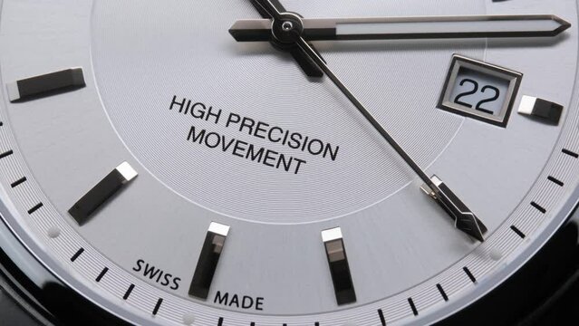 Second arrow running on the black clockface of luxury swiss watch with chronograph. Light flash on the turning clockface. Closeup real time shot. Running second arrow