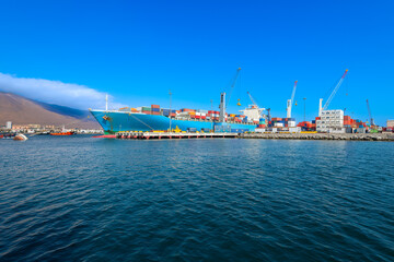 Containers being loaded in a cargo ship at the port of Iquique.