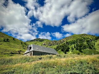 summer mountain of the central massif with an old stone refuge, evoking serenity in the middle of...