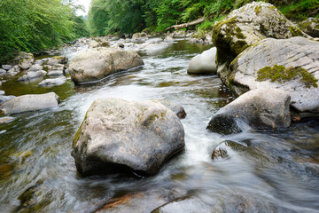 Motion blur of water flowing over rocks in a river