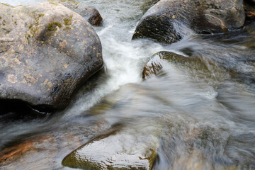 Motion blur of water flowing over rocks in a river
