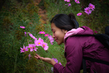 Woman smelling cosmos flowers