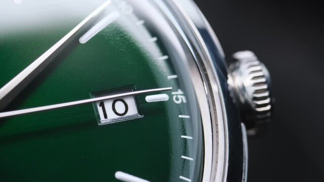 Stylish Luxury Man Wrist Watch With Moving Hand And Multiple Dials. Men's watch in metal with sapphire crystal. Closeup view of rotating watch, running second arrow. green dial. 