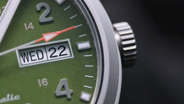 Stylish Luxury Man Wrist Watch With Moving Hand And Multiple Dials. Men's watch in metal with sapphire crystal. Closeup view of rotating watch, running second arrow. green dial. 