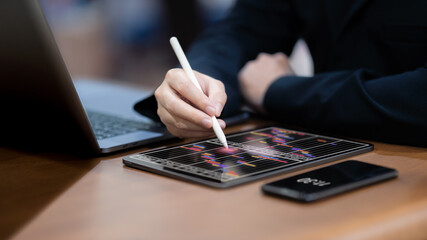 Businessman checks and manages his weekly schedule on a tablet. - obrazy, fototapety, plakaty