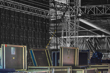 Hinter einer OpenAir Bühne Backstage mit Flycases und Kabelboxen, geöffnete Kisten und Equipment.