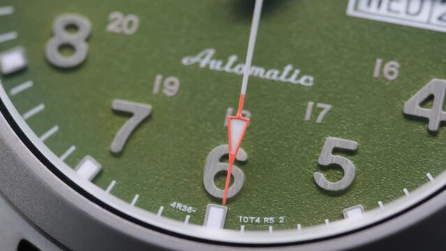 Stylish Luxury Man Wrist Watch With Moving Hand And Multiple Dials. Men's watch in metal with sapphire crystal. Closeup view of rotating watch, running second arrow. green dial. 