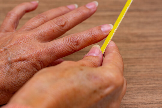 m&atilde;os femininas, branca lixando as unhas