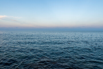 The blue mediterranean sea and a colorful horizon at Cala Ratjada on Majorca Island, Spain - obrazy, fototapety, plakaty