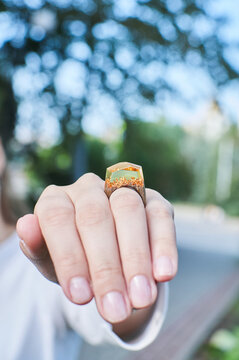 Wooden ring made of epoxy resin on a girl's hand. Women's jewelry made from natural materials.