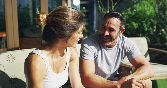 Couple, talking and happy for breakfast on garden patio with love, care or diet with bonding, relax or morning sunshine. Man, woman and eating food on date, health or vacation with chat in backyard