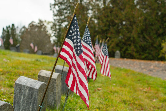 flags in the field, cemetery graves of fallen fir fighters, selective focus copy space image.