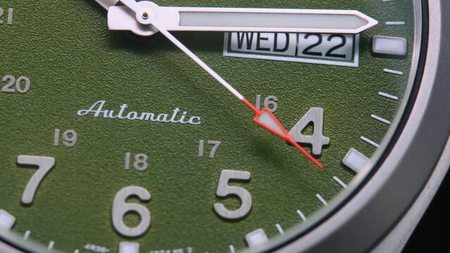 Stylish Luxury Man Wrist Watch With Moving Hand And Multiple Dials. Men's watch in metal with sapphire crystal. Closeup view of rotating watch, running second arrow. green dial. 