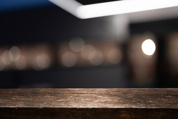 Empty dark wooden table in front of abstract blurred bokeh background of restaurant, window frames. Can be used to display or mount your products. Mock for space.