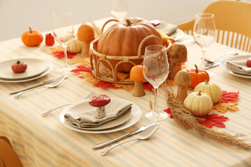 Festive table setting for Thanksgiving Day with pumpkins, leaves and glasses