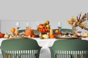 Festive table setting for Thanksgiving Day with pumpkins, dried flowers and pine cones