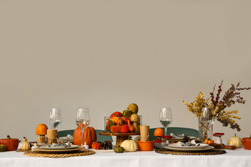 Festive table setting for Thanksgiving Day with pumpkins, dried flowers and pine cones