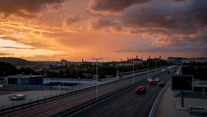 Fototapeta premium View of Prague from the Nuselský Bridge at sunset with the Prague skyline and the castle in the background. Storm clouds.