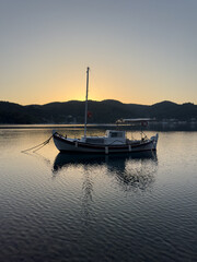 Old fishing boat on the shore in the evening. Ithaca Greece