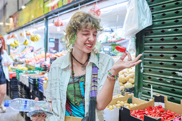 Teenage female at farmer's market, holding bunch of radishes in hands