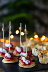 Christmas canapes with blinis with salmon, beetroot and goat cheese and filo pastry cups