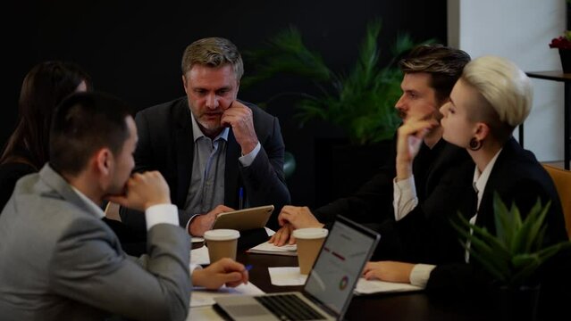 Five businesspeople with boss brainstorming in office. Team of productive colleagues discussion. Unsuccessful process meeting of directors boardroom. Bad news for company.