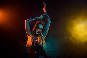 Photo of attractive wild mysterious lady wear viking clothes enjoying ritual dance isolated orange smoke background