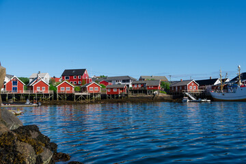Summer in Reine, Lofoten Islands, Norway. Popular tourist destination. Old fishermans village with wooden red cottages Rorbuer - by Classic Norway Hotels