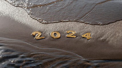 Happy new year 2024 background. 2024 numbers on wet dark golden sand of beach in early morning in...