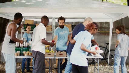 At humanitarian food drive, an elderly Caucasian guy with crutches is aided by a nice black woman....