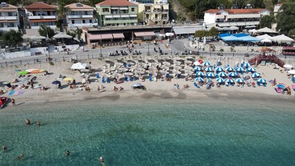 Fototapeta premium Aerial drone view parga greece, beach crowded with tourists in vacation on summer in famous greek caribbean parga town epirus preveza