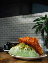 Two Fresh Croissants on a Plate with a Coffee Cup in a Cafe Interior.