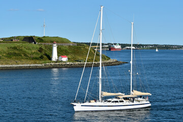A sailboat passes the Georges Island lighthouse at Halifax, N.S. - obrazy, fototapety, plakaty