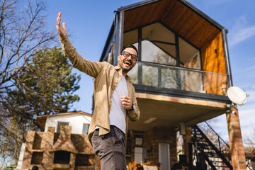 One caucasian man stand in front of modern house gesture invite in