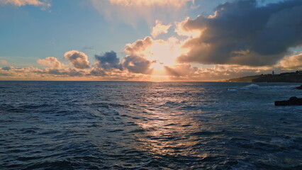 Fototapeta premium Amazing bright marine sunset over ocean surface reflecting evening light aerial.