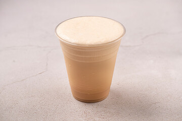 Fresh Ice Tea. Disposable cup on gray background.