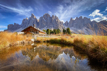 Scenic view of Geisler Alm Rifugio delle Odle in front of dolomites mountains and reflection in the...