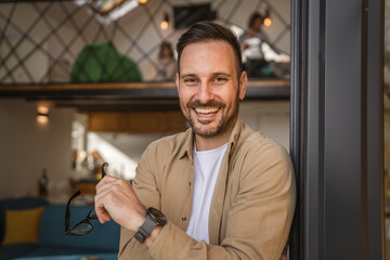 One adult man stand in at door of tiny house happy smile