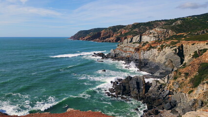 Sunny marine scenery stormy sea washing rocky coastline. Drone waves splashing