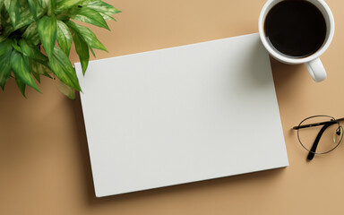 White blank book on the table with coffee. View from the above on the table. Decorative background.