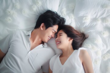 Asian couple lying in bed with complicity and looking each other with love. White background sheets