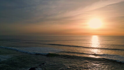 Sunrise sea rippling water beach aerial view. Dawn sky over dark serene ocean