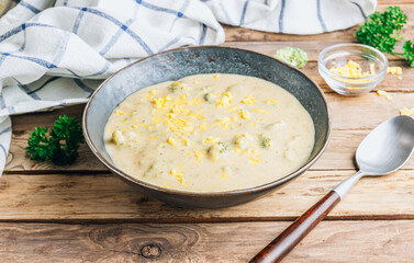 Traditional recipe of broccoli cheese soup with potato in a bowl