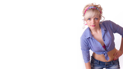 blue-eyed blonde in a blue shirt and jeans looks at the camera. Isolated on a white background. Banner. Space for text.